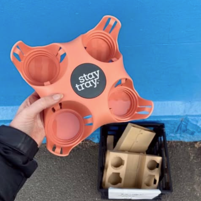 Pink Stay Tray next to single use reusable drink trays