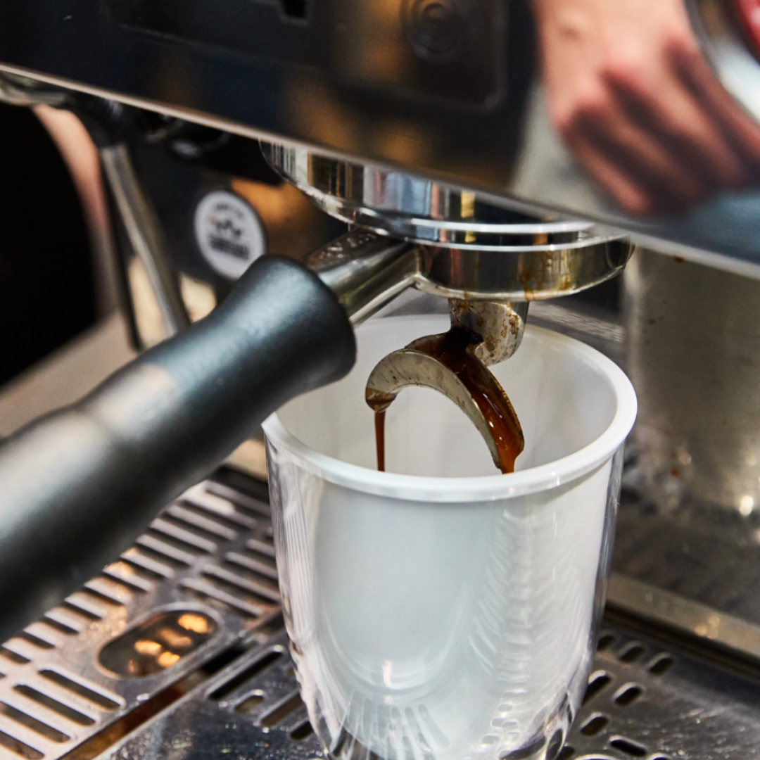 Image of coffee pouring into an Uppercup, aligning perfectly under the spout, highlighting Grounded Goods’ precision-designed, reusable coffee cups for eco-conscious cafes and businesses