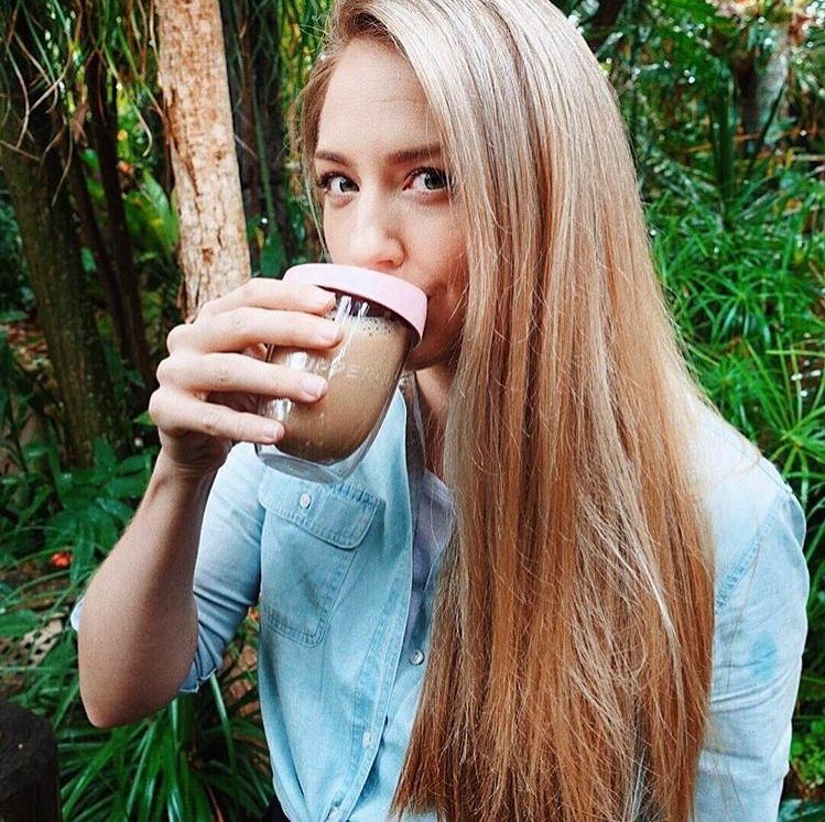 Woman enjoying a beverage from her Grounded Goods Uppercup, showcasing the stylish, sustainable choice for eco-conscious individuals